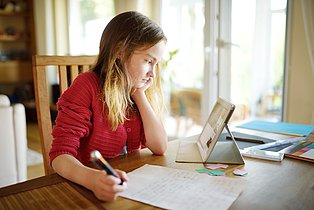 Junge Frau vor Laptop am Schreibtisch