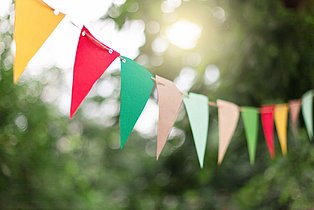 Bunte Wimpel vor Bäumen